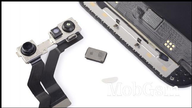 The new chip next to the cameras, display and a grain of rice (image: iFixit)